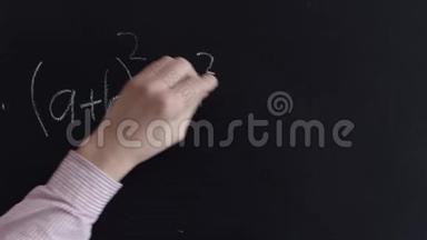 一个人`手在<strong>黑板上用粉笔</strong>写一个数学公式。